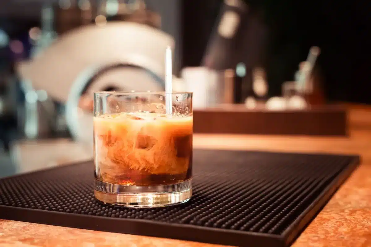 Horchata White Russian cocktail with cinnamon dust on dark wood