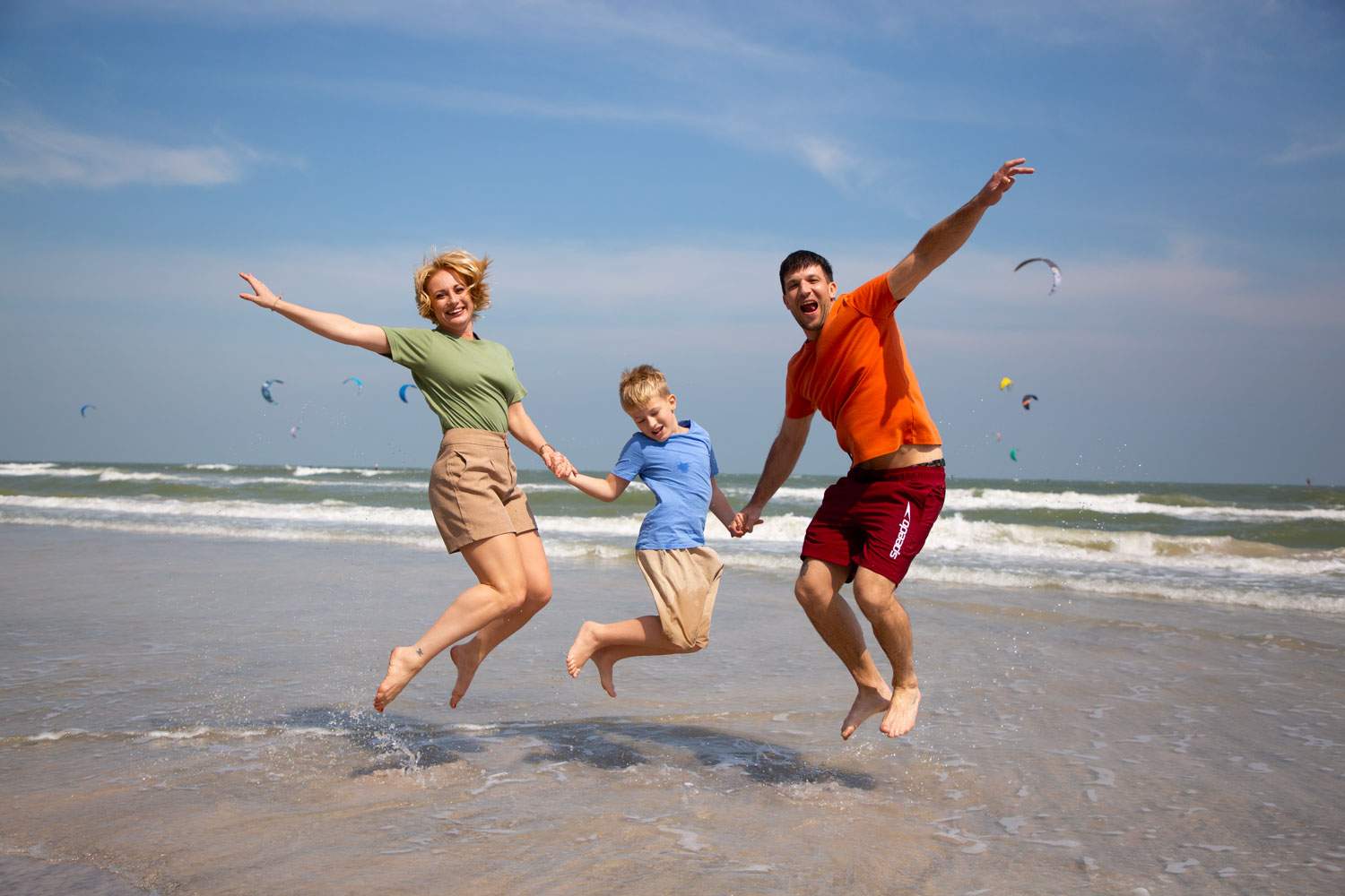 The Mangoes and Palm Trees family jumping for joy on the beach
