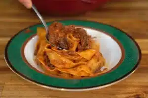 Lamb Ragu d'Abruzzo Recipe: Simple & Delicious 3 Lamb Ragu D'Abruzzo Rose Mary Recipe served with fresh pasta in a plate, showingcasing a rich, savory sauce and tender meat chunks.