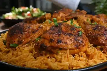 Delicious Chicken Kabsa Rice with perfectly spiced, tender grilled chicken on a bed of fragrant basmati rice, garnished with fresh herbs – a traditional Middle Eastern dish full of rich flavors.