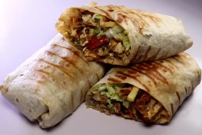Delicious Lebanese Chicken Shawarma wrap with grilled, marinated chicken, fresh vegetables, and flavorful sauces, served in a warm pita or flatbread.