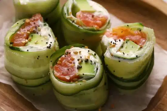 Smoked Salmon Roulade on Cucumber Chatelaine a gourmet appetizer featuring thinly sliced cucumber wrapped around smoked salmon, cream cheese, and avocado, topped with seasoning for a fresh and elegant presentation