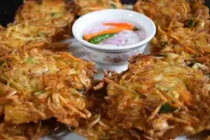 Sweet Potato Ukoy with Palabok Recipe, crispy fritters served with vinegar dip and garnished with onions and peppers.