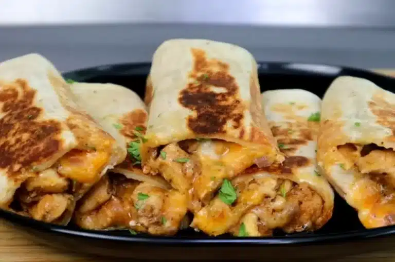Delicious Cheesy Garlic Chicken Wraps with golden crispy tortillas, melted cheese, and flavorful seasoned chicken, garnished with fresh herbs. A mouthwatering savory meal perfect for lunch or dinner.