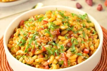 Delicious Ronzoni Macaroni Salad made with fresh vegetables, flavorful dressing, and tender elbow pasta, garnished with herbs for a perfect side dish.