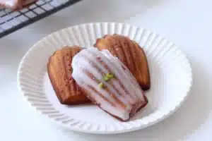 Freshly baked Madeleine cookies with a creamy texture, drizzled with sweet glaze and garnished with pistachios. Perfect for a Madeline Cookies Recipe Using Cream.