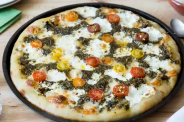 Tomato Halves Chimichurri Recipe for Pizza topped with colorful cherry tomatoes, chimichurri sauce, and melted cheese on a crispy homemade crust.