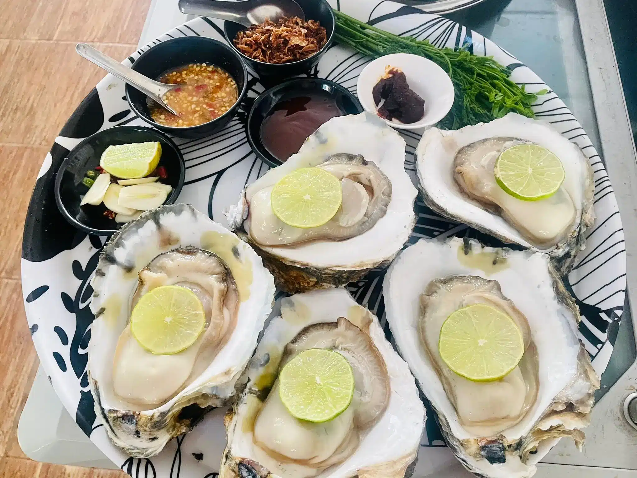 A close-up of beautiful, plump oysters with their flavourful accompaniments.