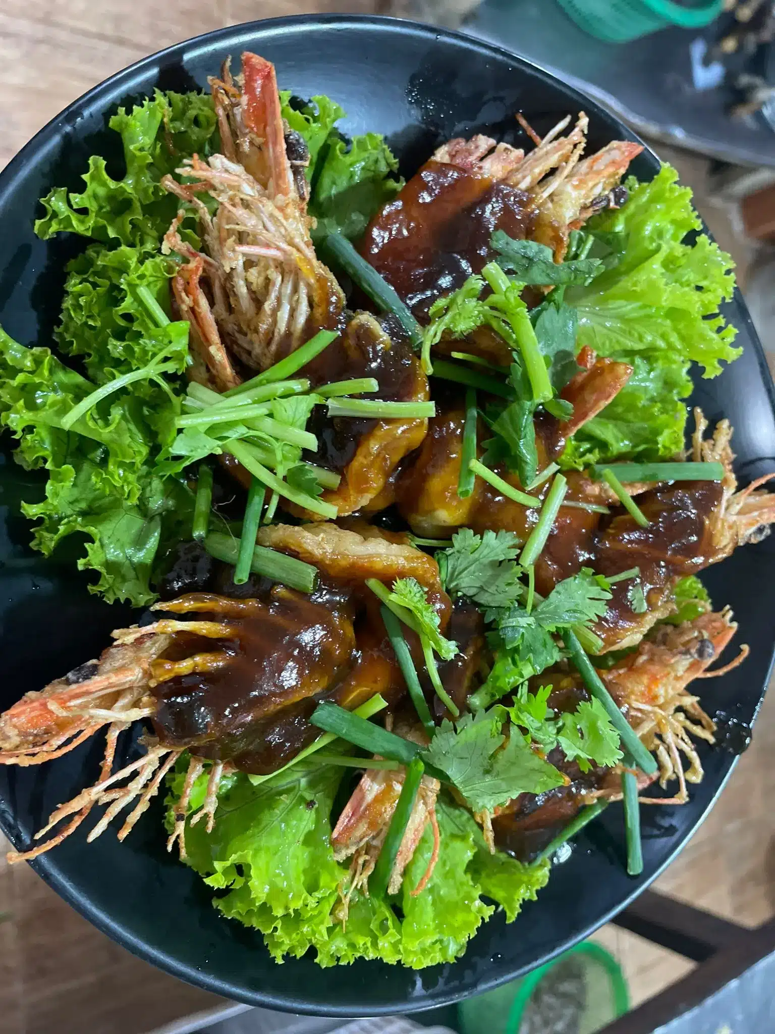 Prawns coated in a dark, glossy tamarind sauce.