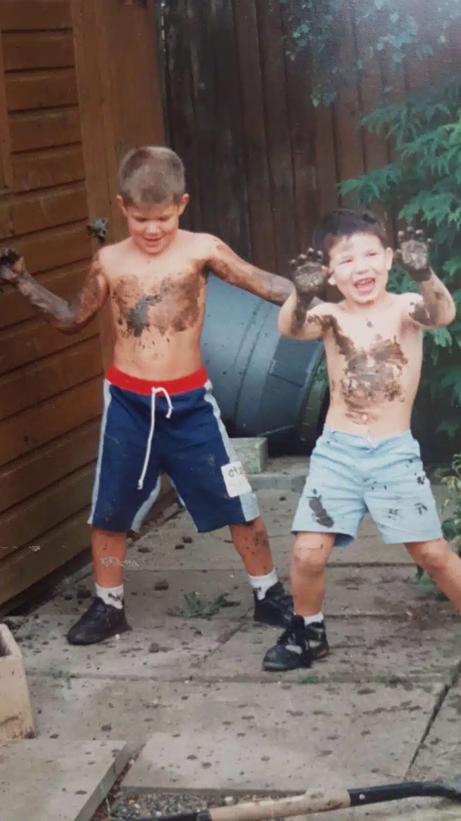 A childhood photo of young Oliver and Daniel Mayerhoffer covered in mud in their garden in Cheltenham, UK.