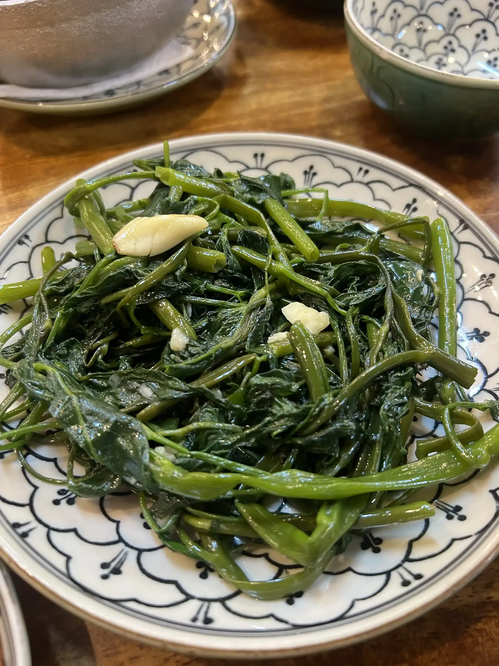 Discover Da Nang in 2025: The Most Comprehensive Travel Guide to Vietnam’s Coastal Gem 8 Steamed water spinach with garlic on a decorative porcelain plate, fresh and healthy vegetables.
