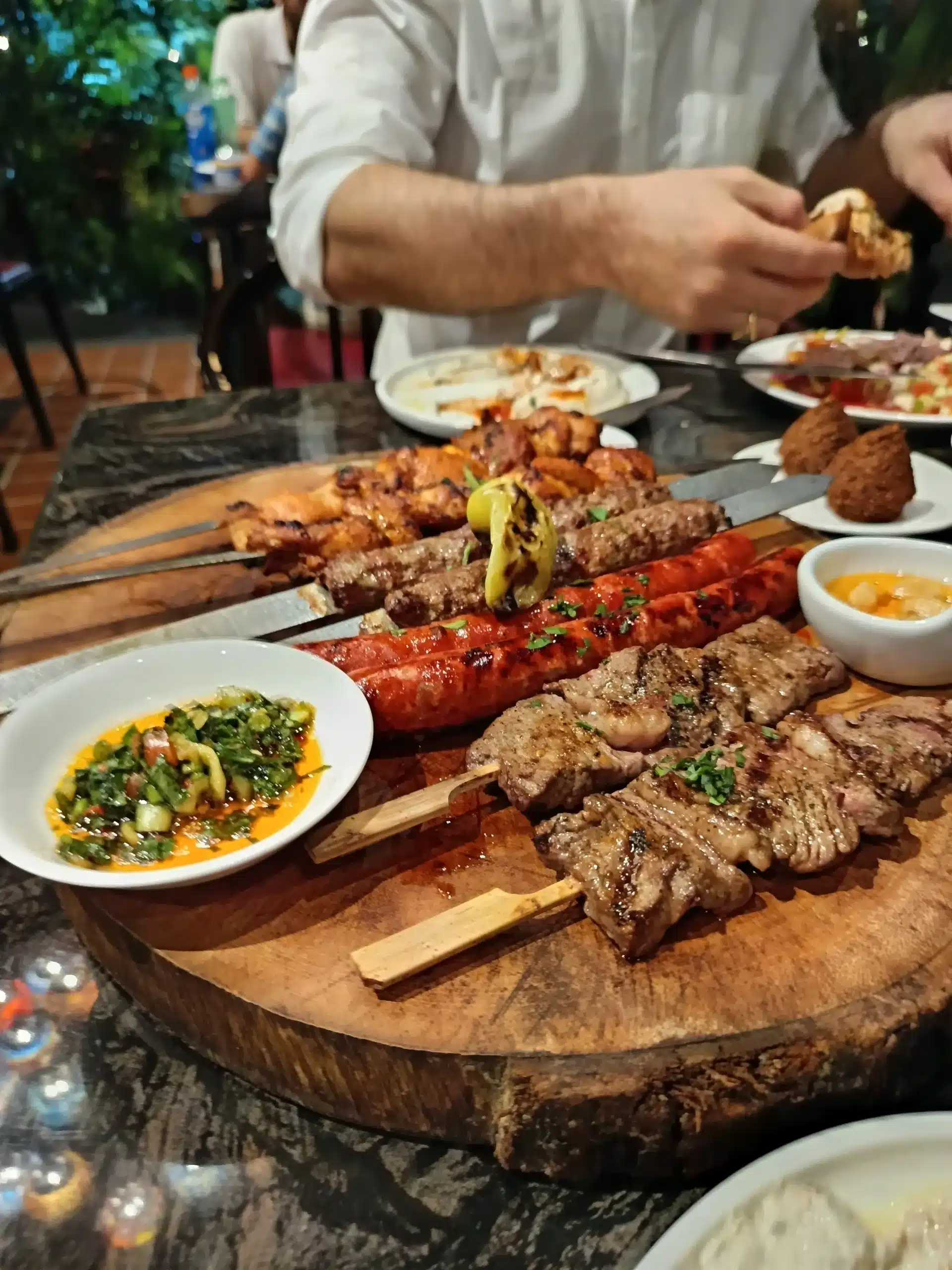 Close up of mixed meat kebabs and kofta on a wooden board at Ogen