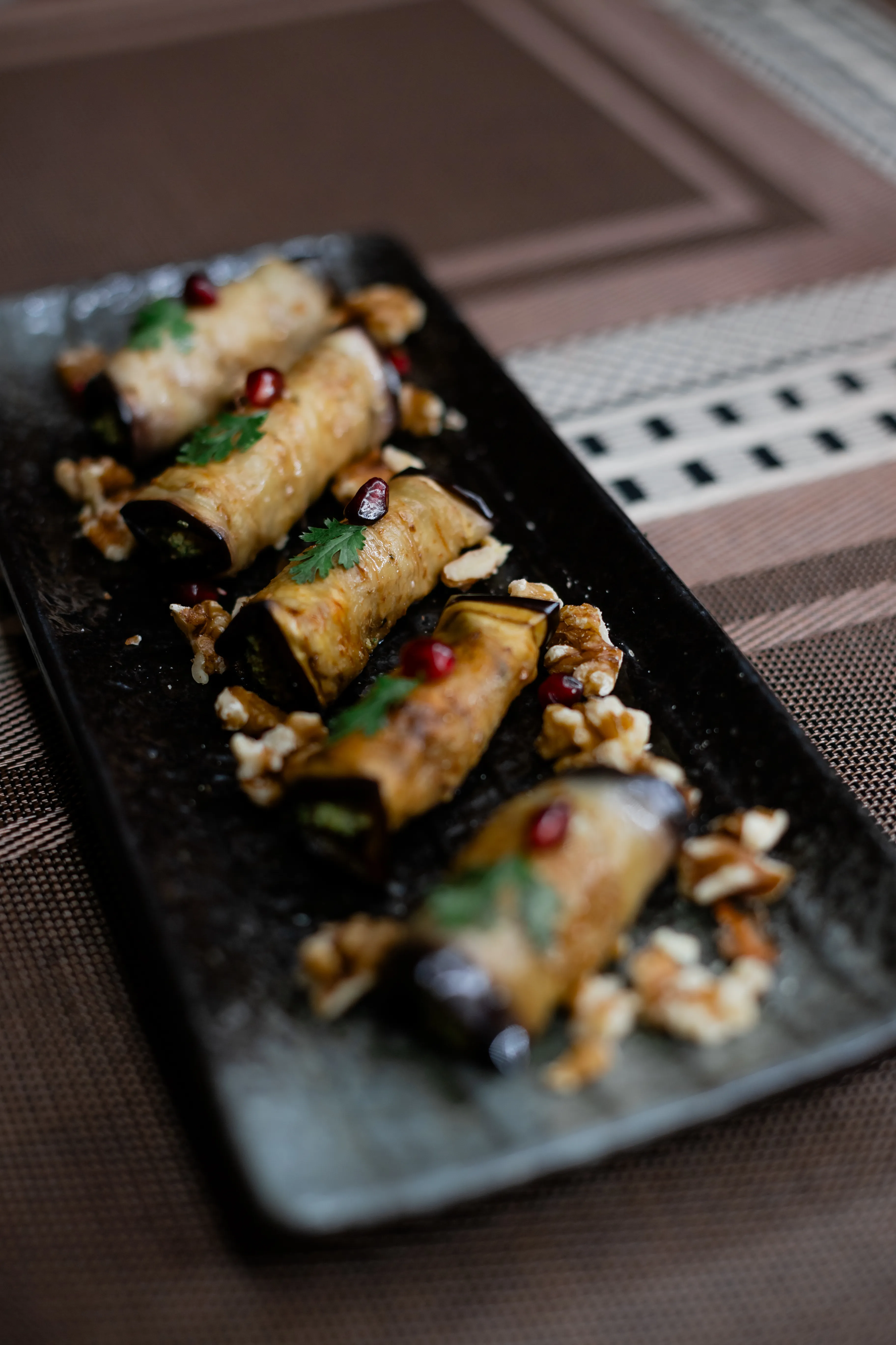 Natalia Mayerhoffer verifying authentic Georgian Nigvziani Badrijani eggplant rolls at Hinkali House Hua Hin, demonstrating heritage preservation for Mangoes and Palm Trees.