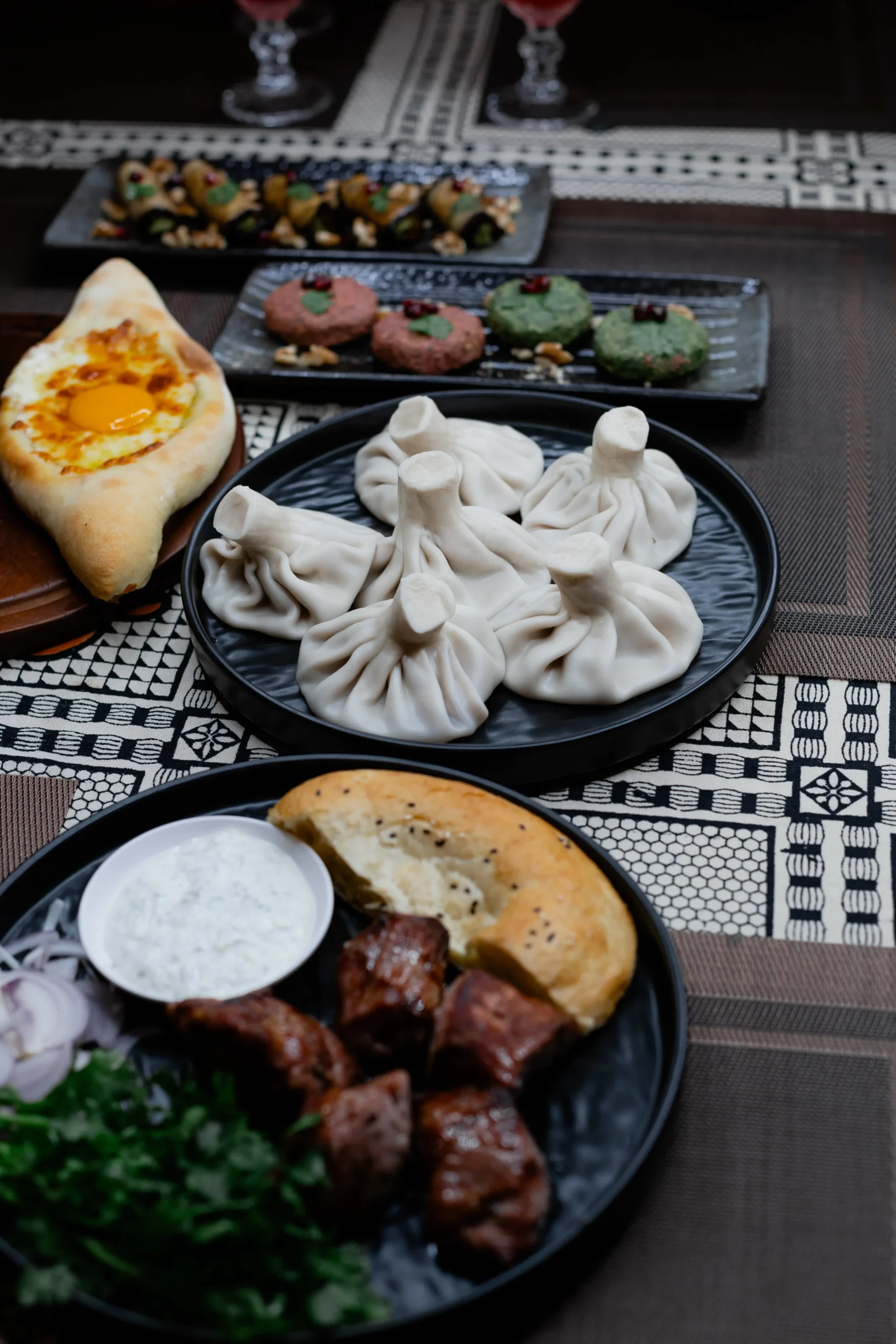 The large shared Georgian table at Hinkali House Hua Hin featuring authentic khinkali dumplings, Adjarian khachapuri, and fresh salads, documented during our family travel in Thailand.