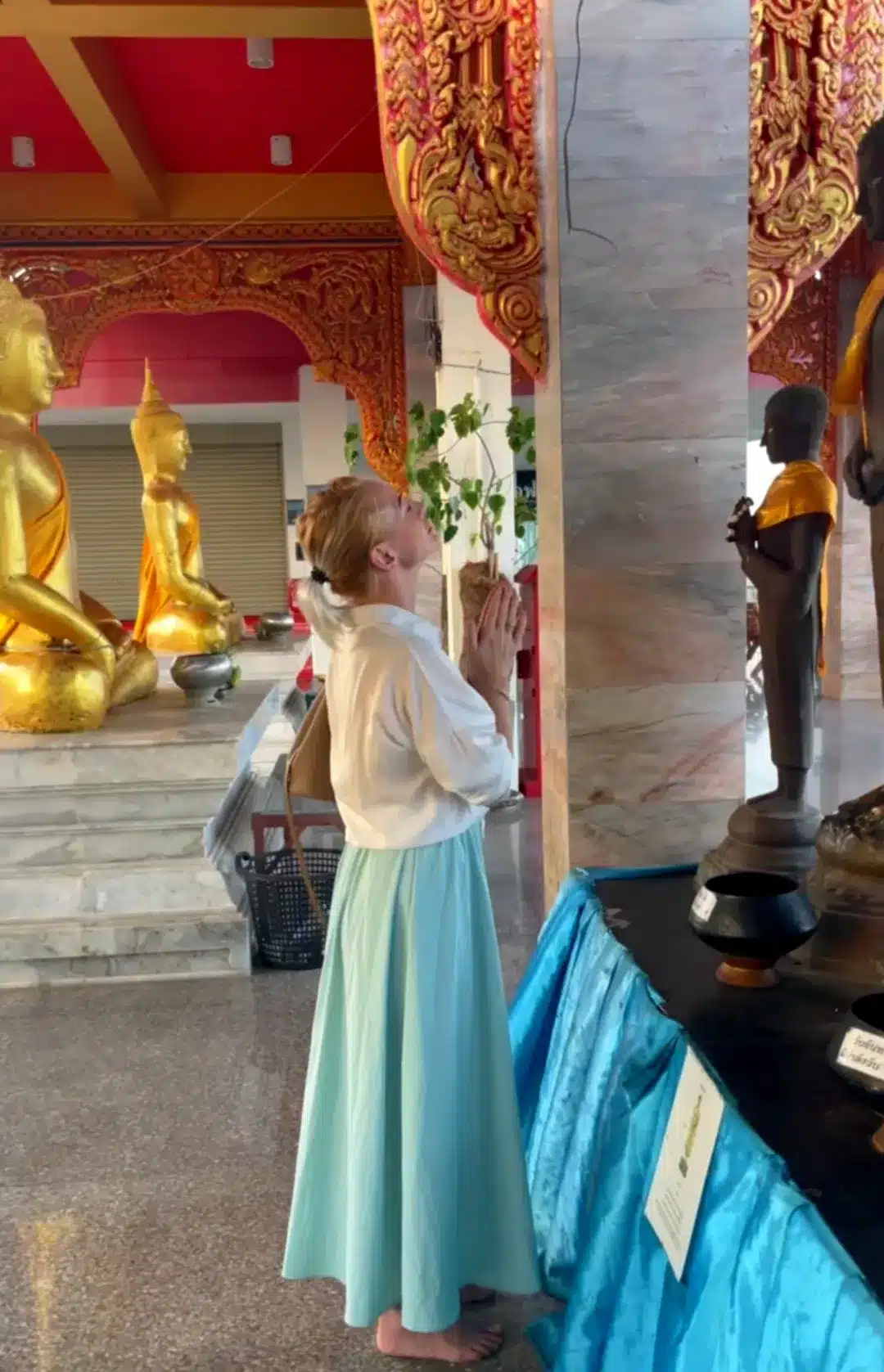 Natalia Mayerhoffer praying stood up at Wat Khao Noi Hua Hin landmarks April 2026
