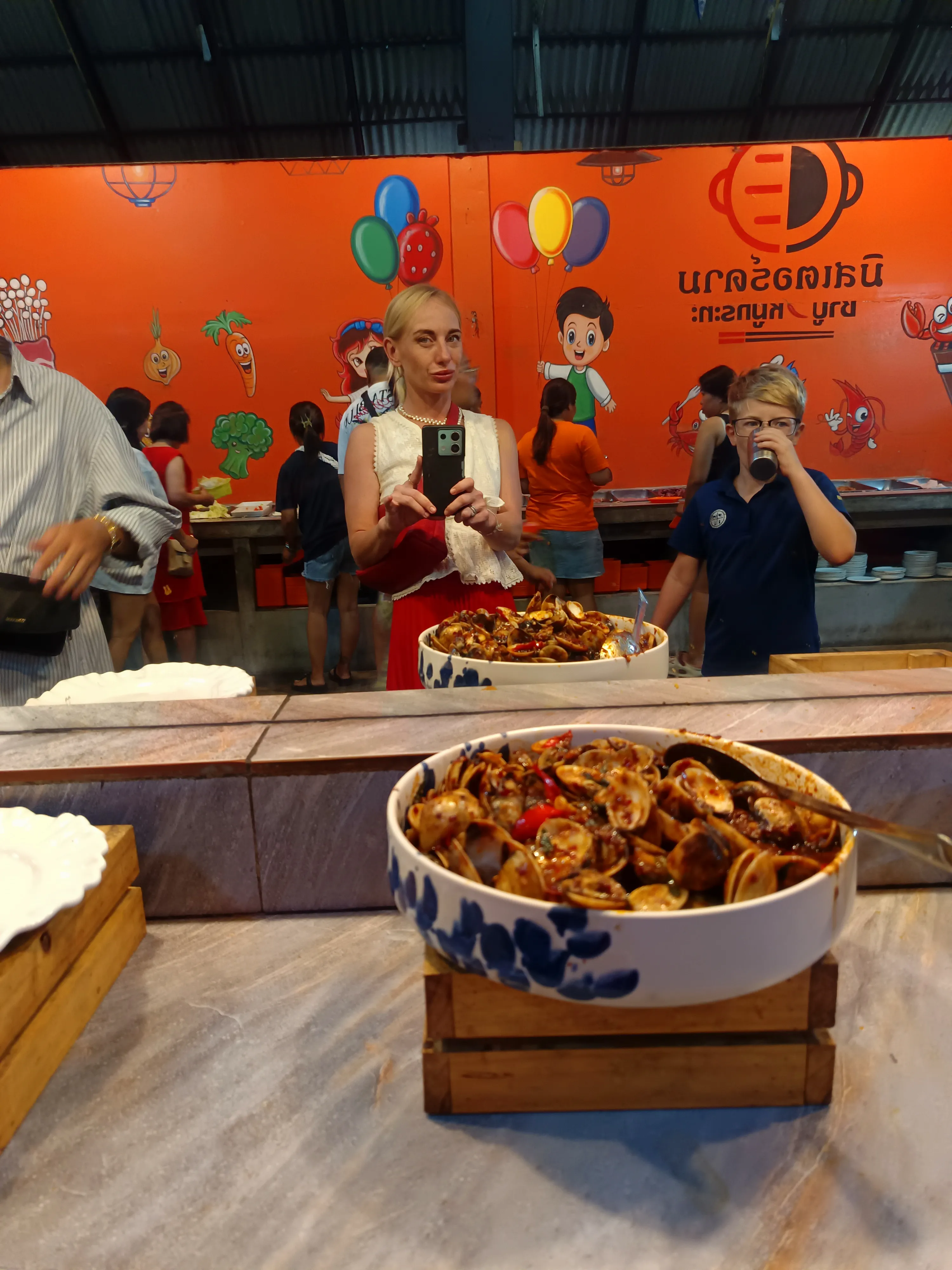 Natalia and Victor filling plates at Mr. Dum before grilling at our table