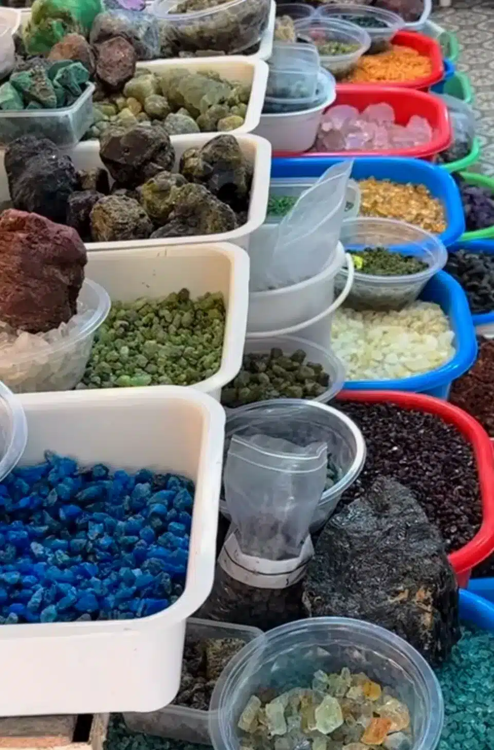Sorted cut and uncut gemstones on a trader's table in Chanthaburi, Thailand