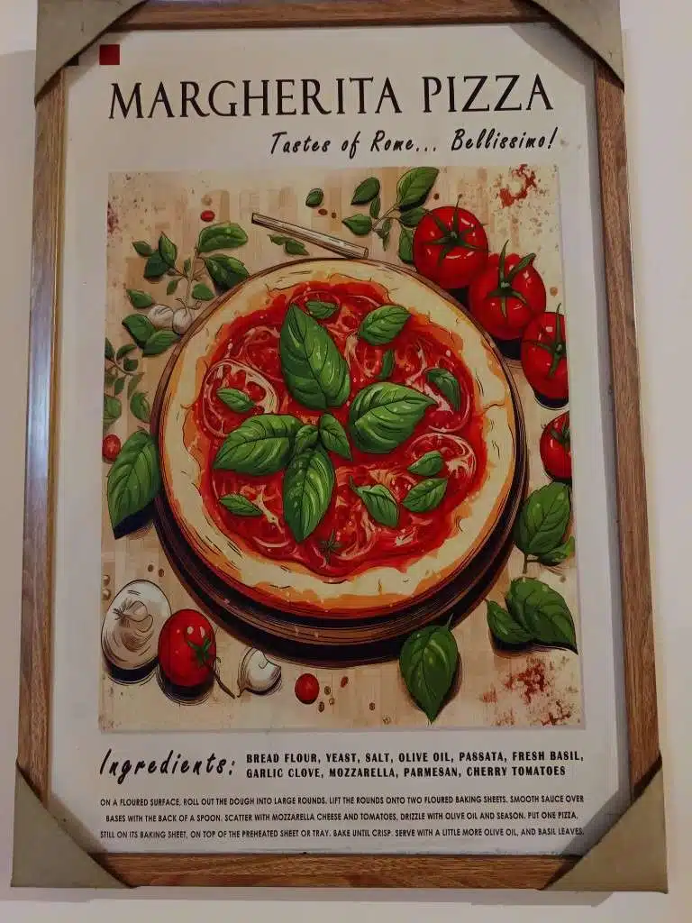 Wall sign at Pizza 100 displaying a Margherita pizza illustration and ingredient list