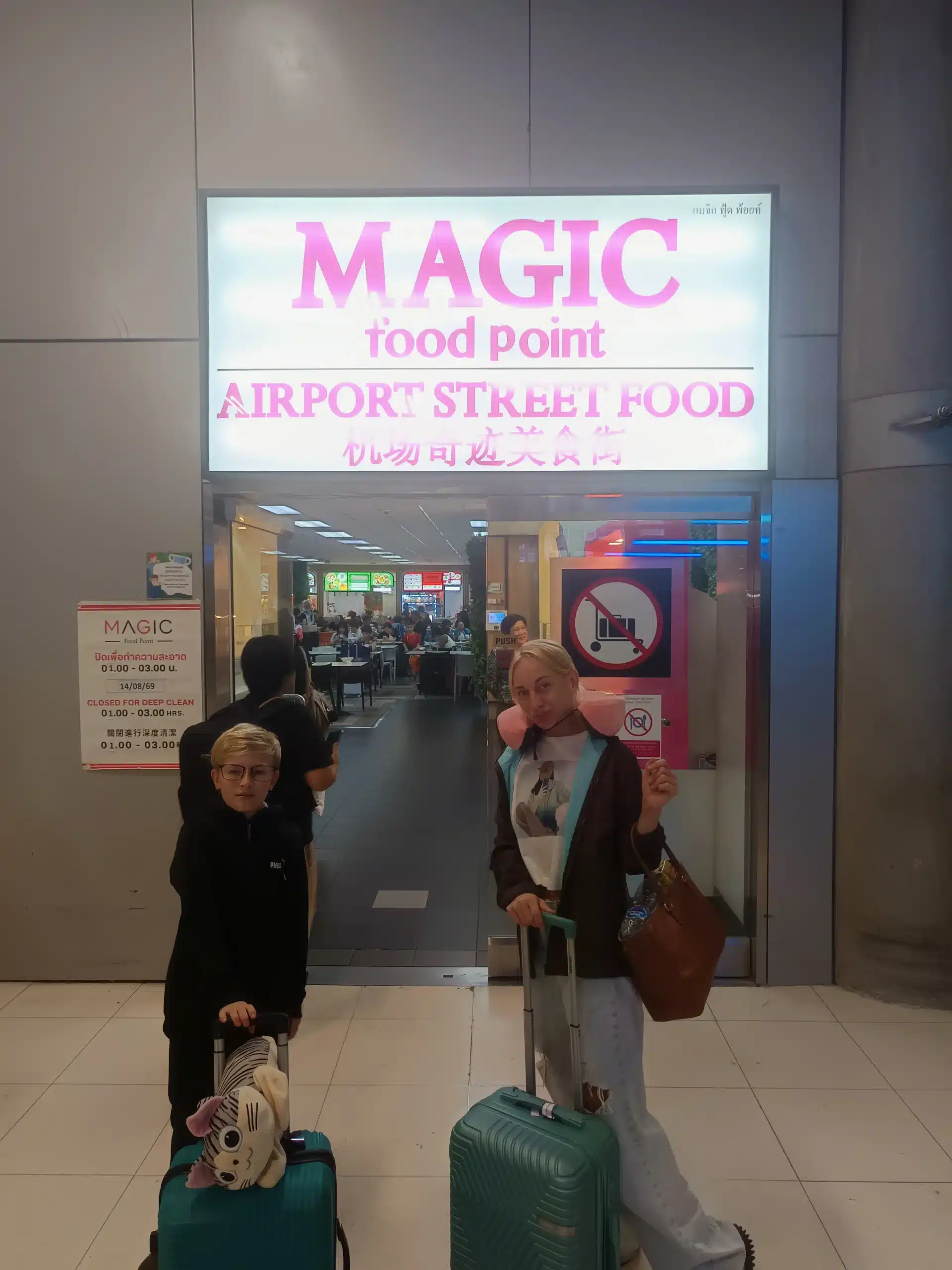 Family members with luggage at the entrance to Magic Food Point at Suvarnabhumi Airport